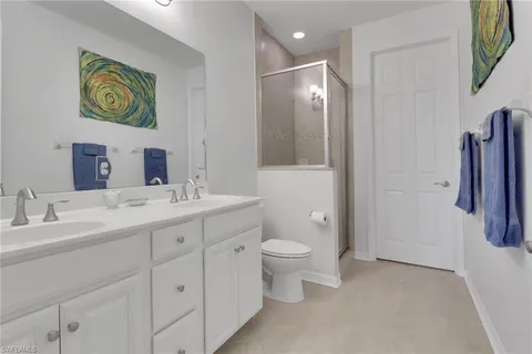 a bathroom with a double vanity sink a toilet and a mirror