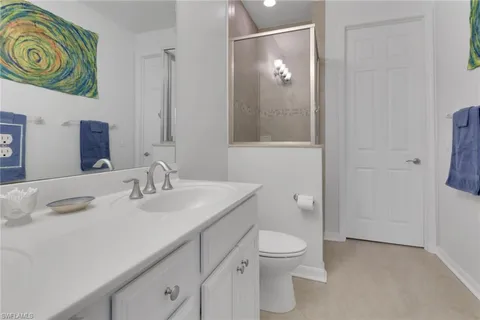 a bathroom with a granite countertop sink a toilet and a mirror