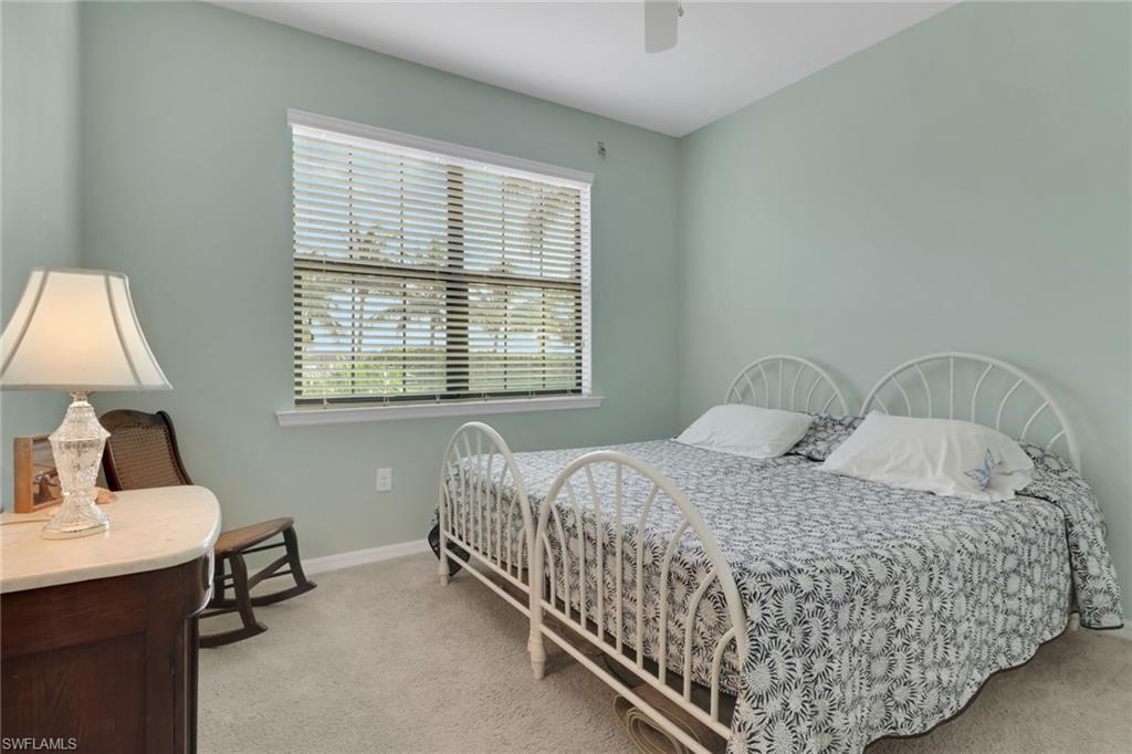 26233 Palace Lane, Unit 201 Bonita Springs, FL 34135 - Photo 19 of 46 a bedroom with a bed and a table in it