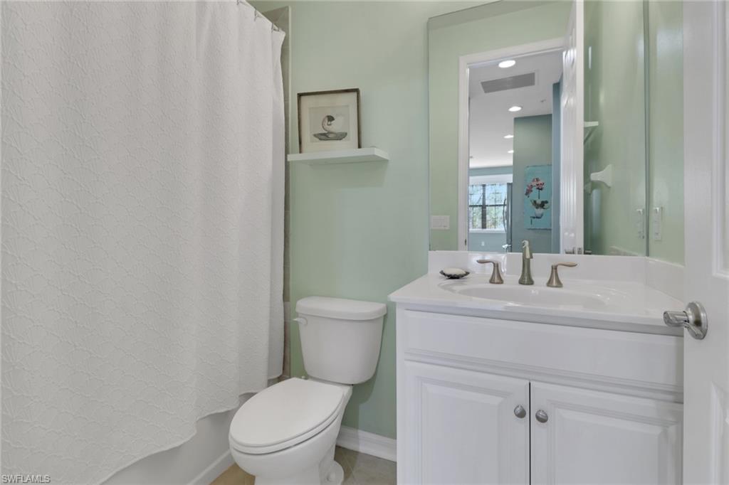 26233 Palace Lane, Unit 201 Bonita Springs, FL 34135 - Photo 21 of 46 a bathroom with a toilet sink vanity and mirror