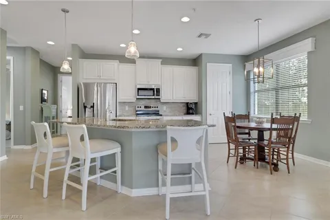 a kitchen with kitchen island granite countertop wooden cabinets and a dining table
