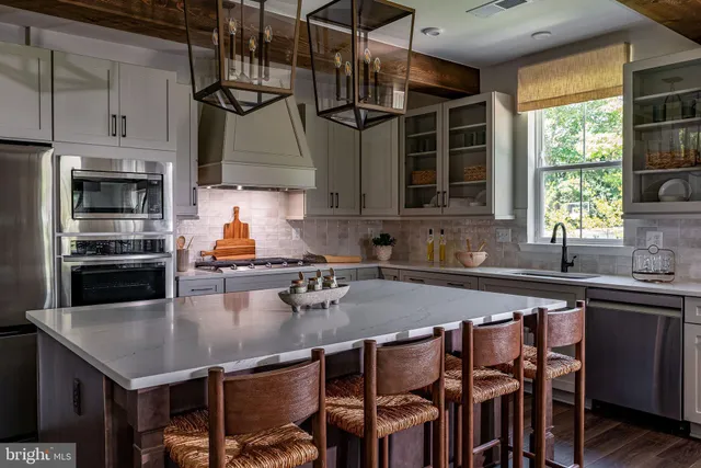 a kitchen with stainless steel appliances granite countertop a sink a stove and a refrigerator