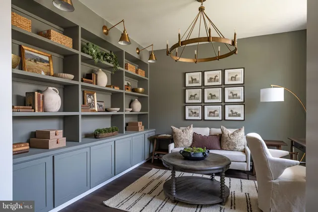 a living room with furniture a rug and a book shelf