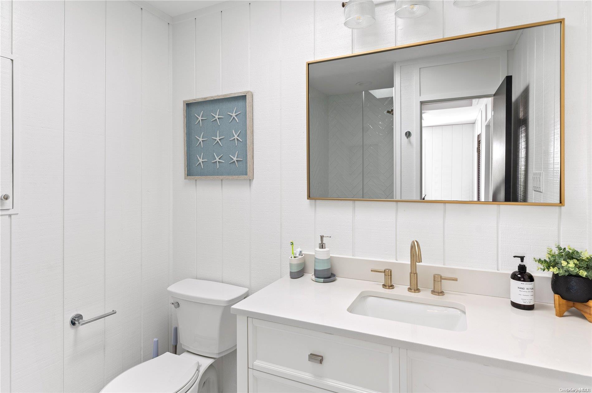 220 Cottage Walk Ocean Beach, NY 11770 - Photo 17 of 32 a bathroom with a toilet a sink and mirror