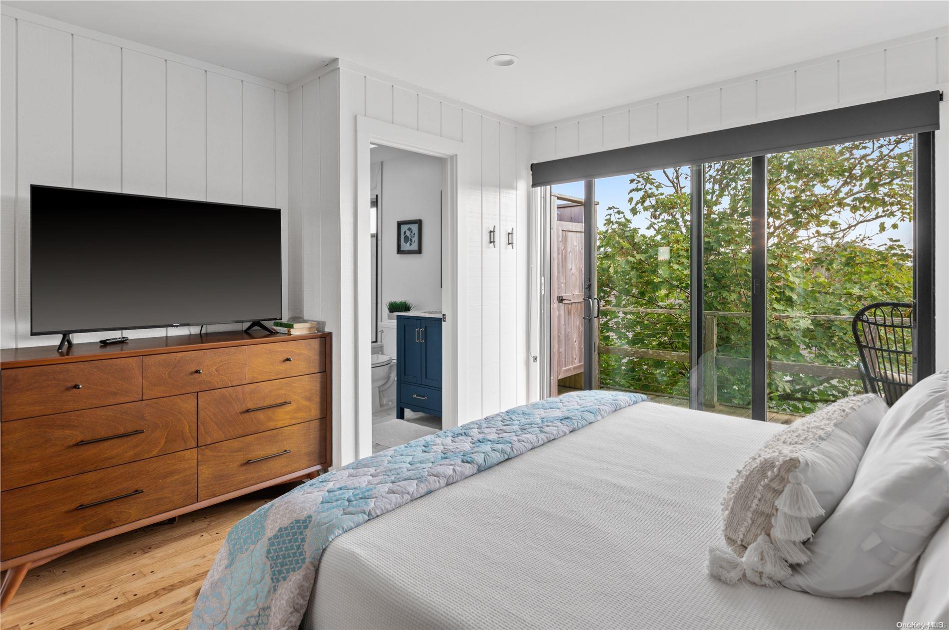 220 Cottage Walk Ocean Beach, NY 11770 - Photo 19 of 32 a bedroom with a large bed and a flat screen tv