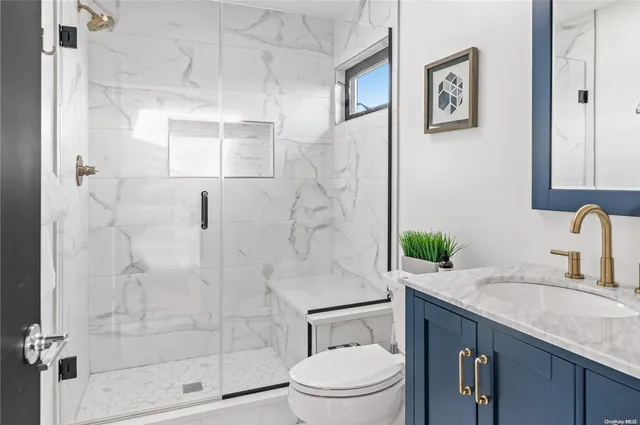 a bathroom with a granite countertop sink a toilet and shower