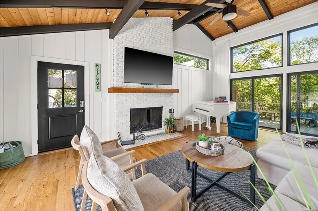 a living room with furniture a fireplace and a floor to ceiling window