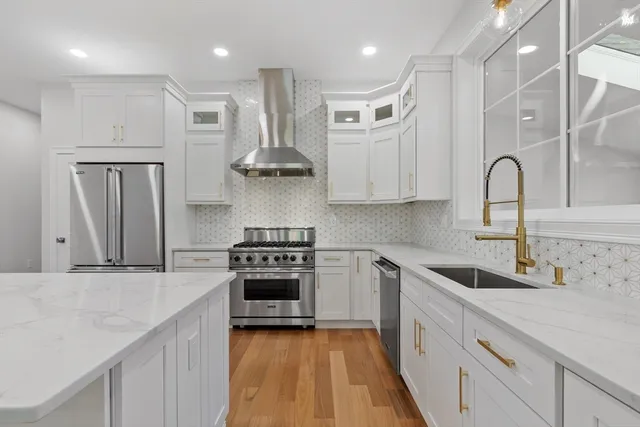 a kitchen with stainless steel appliances granite countertop a sink stove and refrigerator