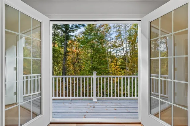 a view of an empty room with wooden floor and window