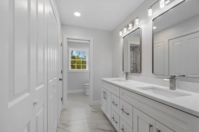 a bathroom with a shower sink vanity mirror and toilet