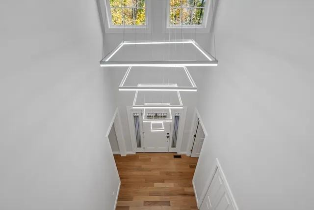 a view of a hallway with windows and chandelier