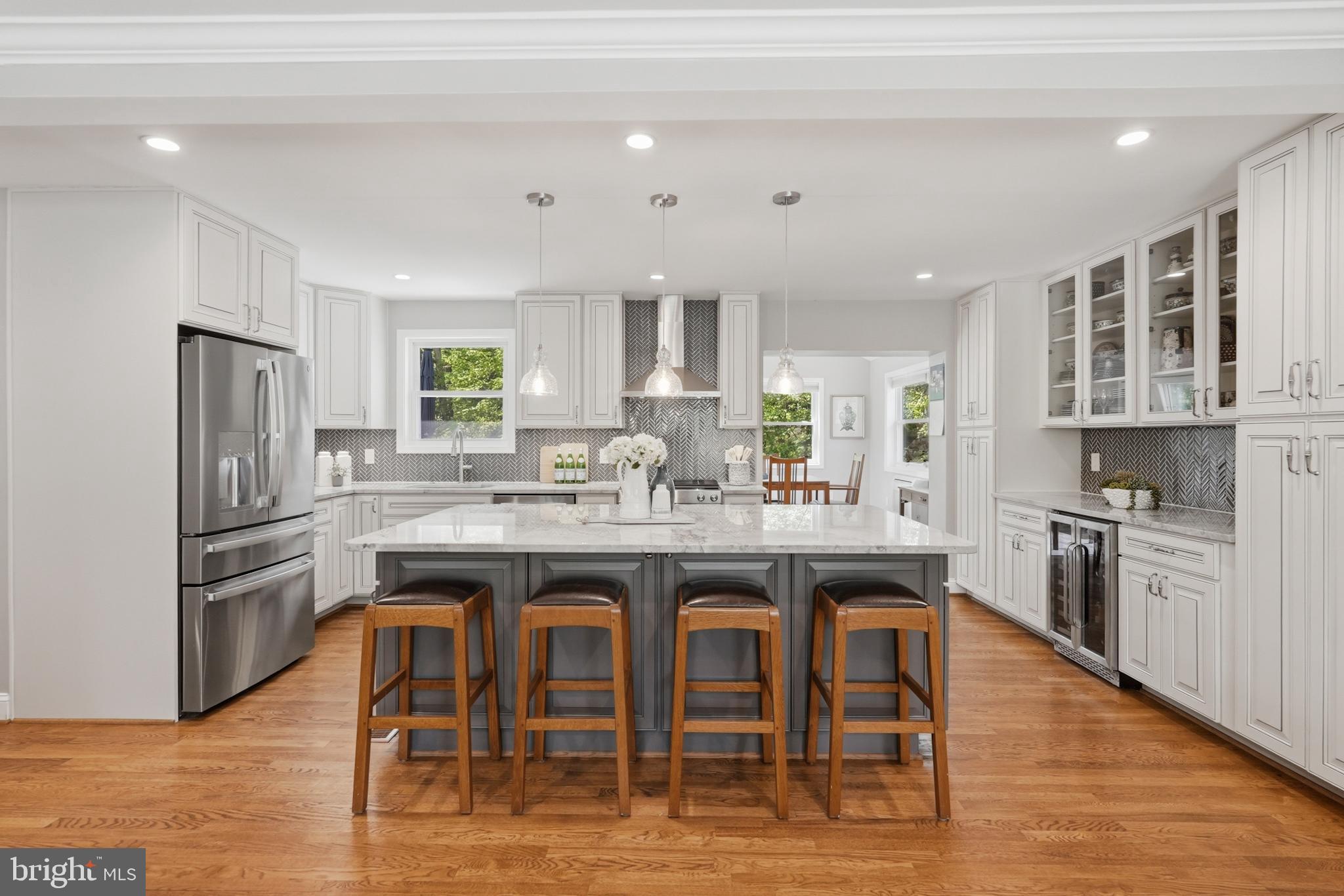 7006 Barnack Drive Springfield, VA 22152 - Photo 10 of 56 a kitchen with stainless steel appliances granite countertop a dining table chairs refrigerator and sink