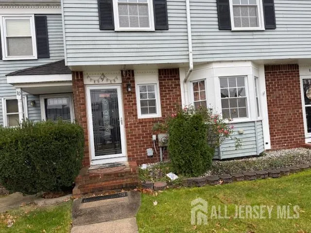 a view of a house with potted plants and a yard in front of house