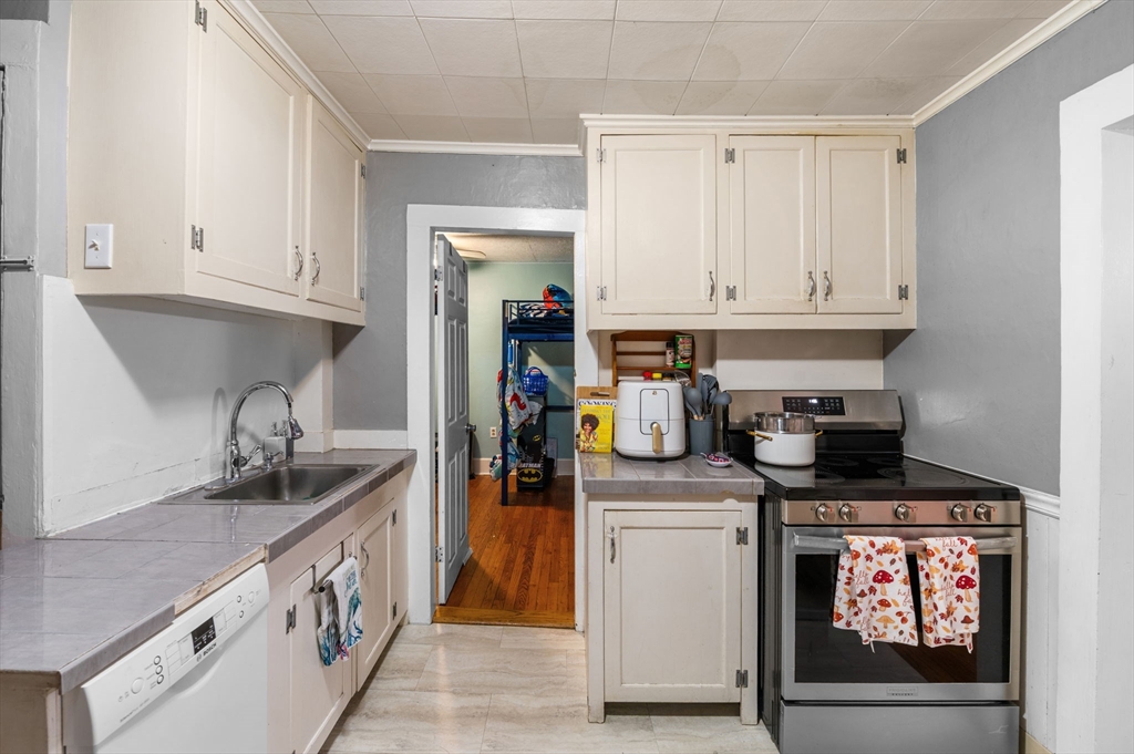 27 Appleton Street Salem, MA 01970 - Photo 7 of 31 a kitchen with stainless steel appliances granite countertop a sink and cabinets