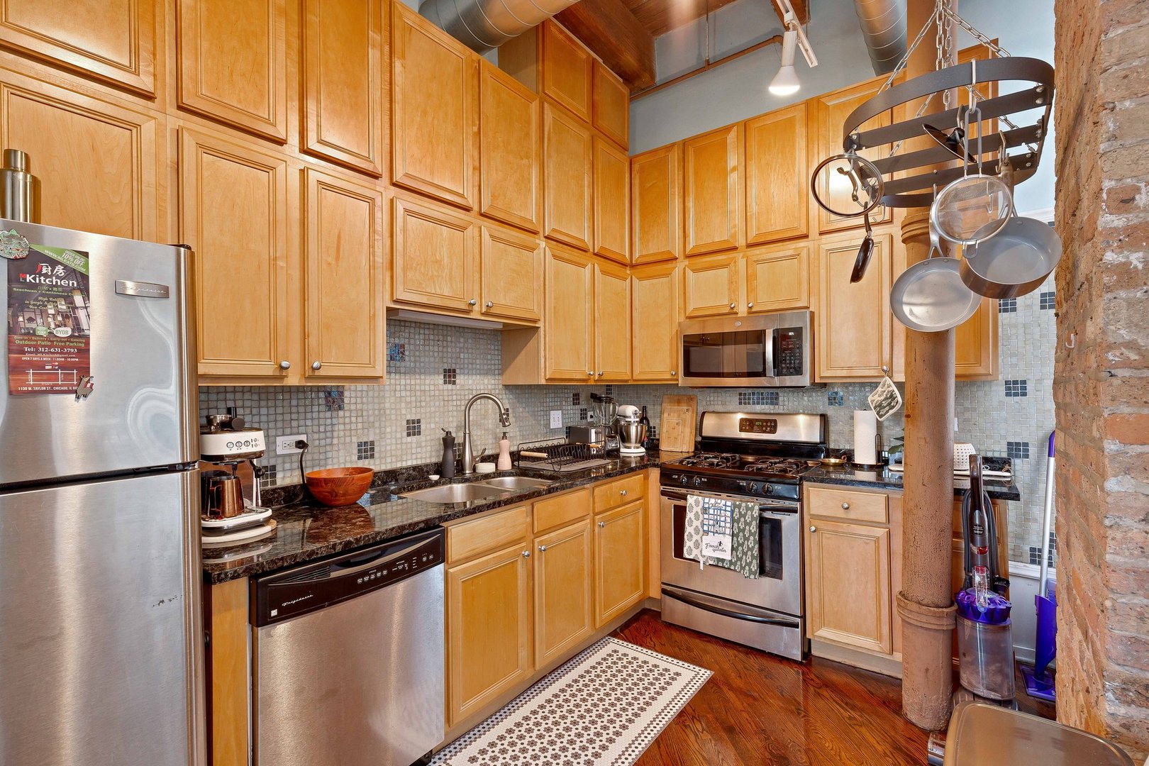 550 West Harrison Street, Unit 353 Chicago, IL 60607 - Photo 5 of 16 a kitchen with stainless steel appliances a sink a stove a refrigerator and cabinets
