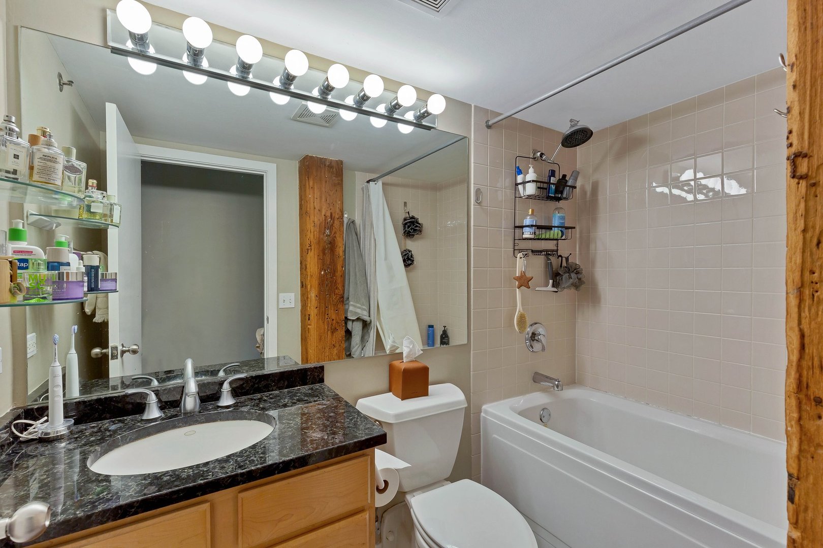 550 West Harrison Street, Unit 353 Chicago, IL 60607 - Photo 7 of 16 a bathroom with a granite countertop sink a toilet a mirror and shower