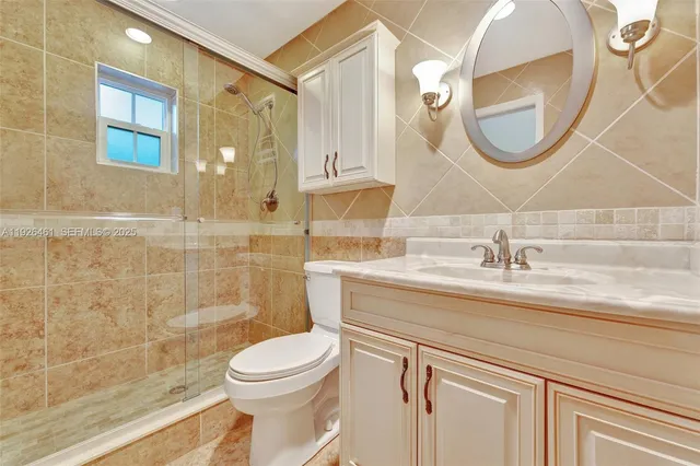 a bathroom with a granite countertop toilet sink and mirror
