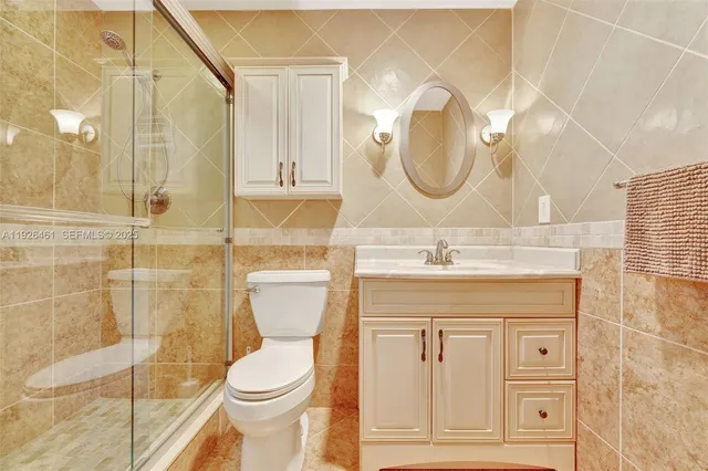 a bathroom with a granite countertop toilet a sink and a mirror