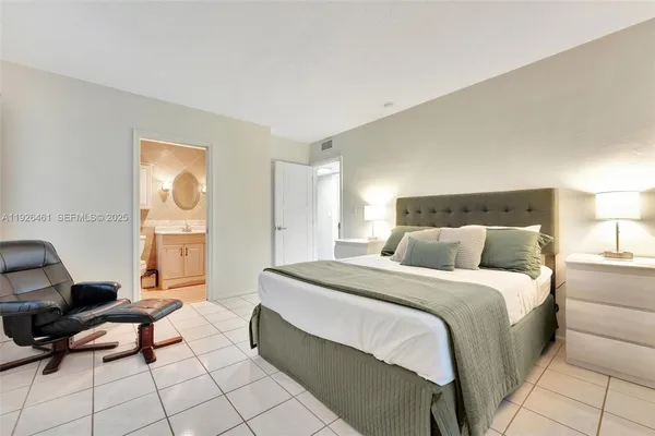 a spacious bedroom with a bed a couch and dresser