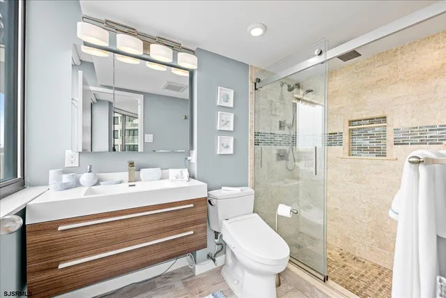 a bathroom with a sink toilet a mirror and shower