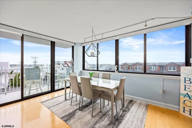a dining room with furniture and a floor to ceiling window