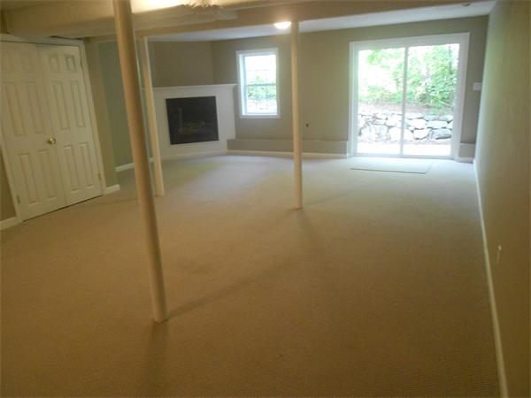 6 Longfellow Road, Unit B Groton, MA 01450 - Photo 8 of 11 a view of an empty room with a fireplace and a window