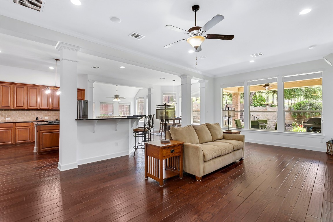 a living room with stainless steel appliances kitchen island furniture and a large window