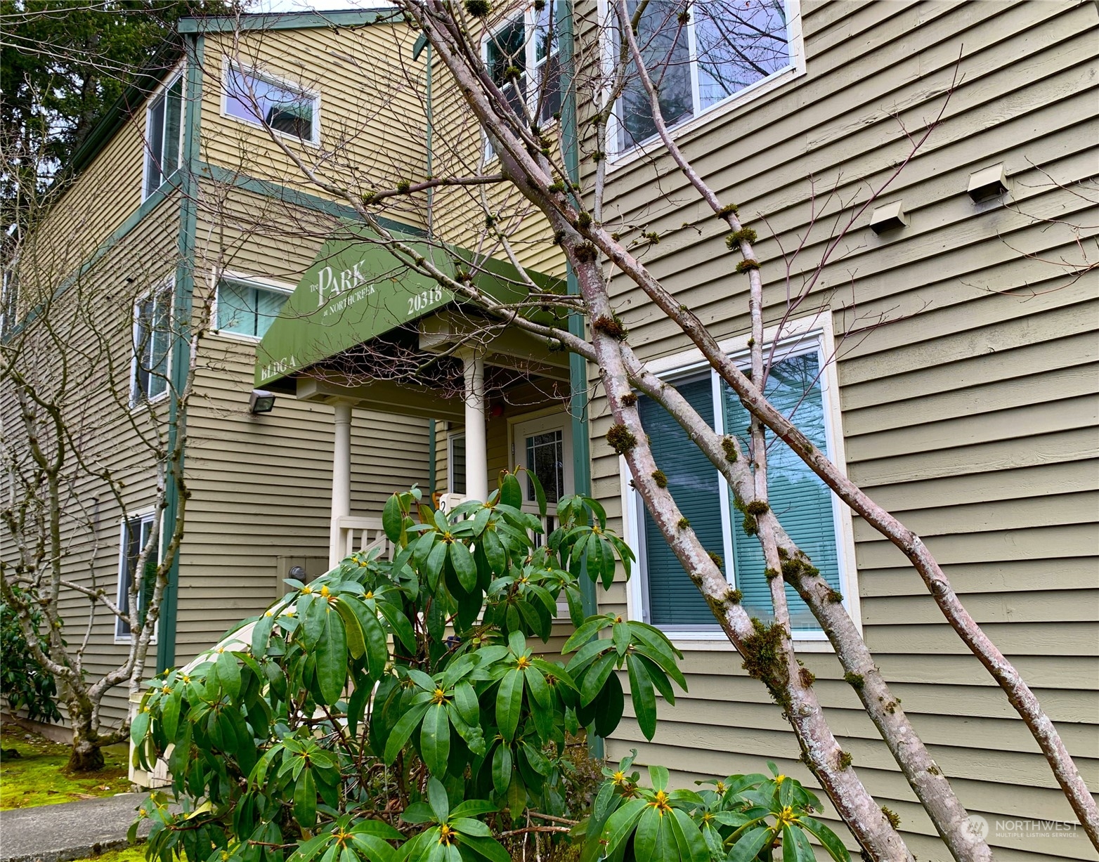 a yellow and white house with a flower garden