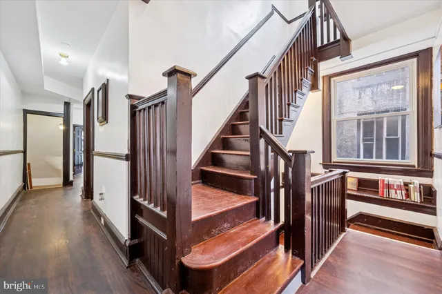 a view of staircase with lots of frames on wall and a window
