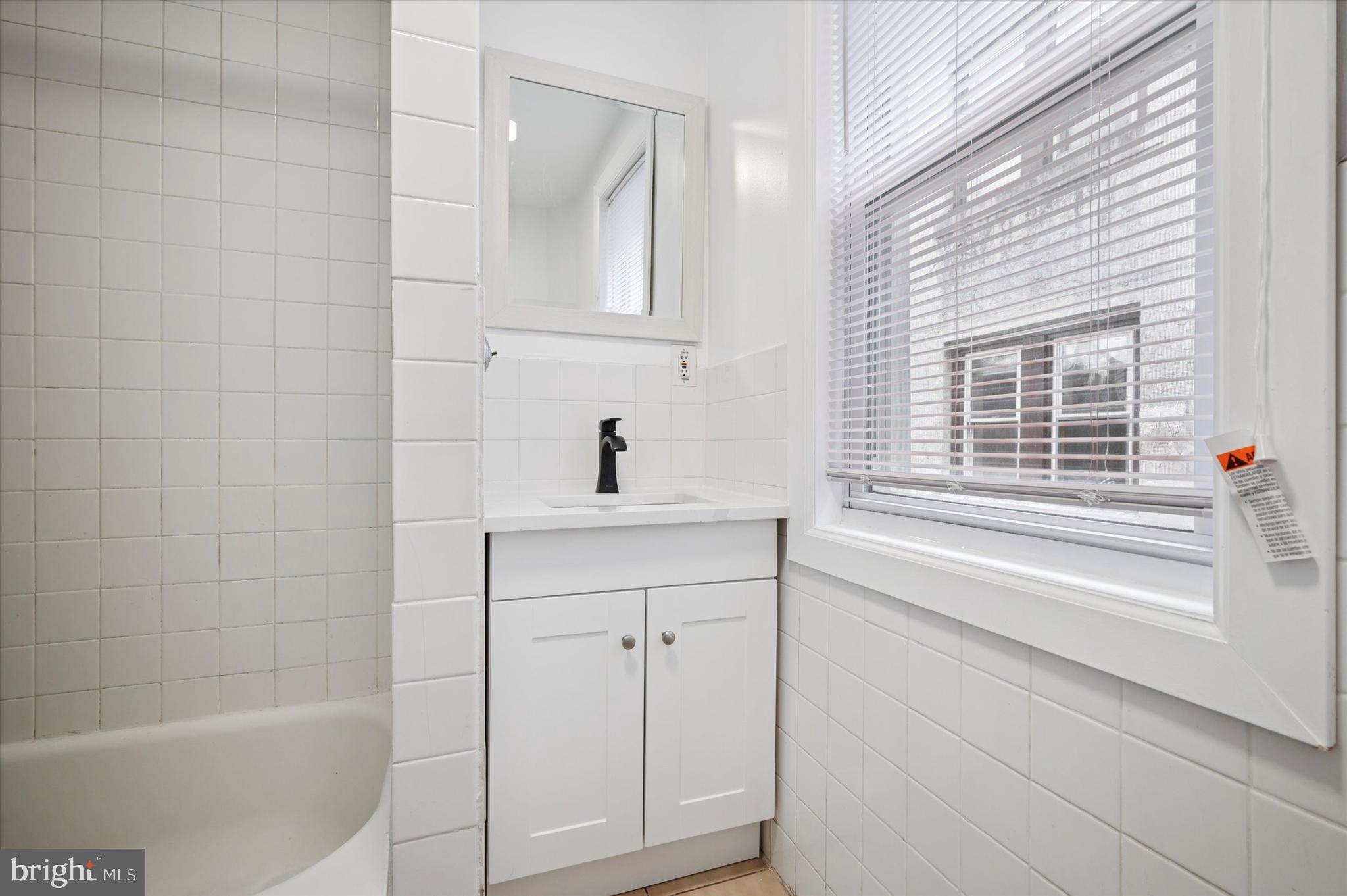 4518 Walnut Street Philadelphia, PA 19139 - Photo 14 of 36 a bathroom with a shower sink and vanity
