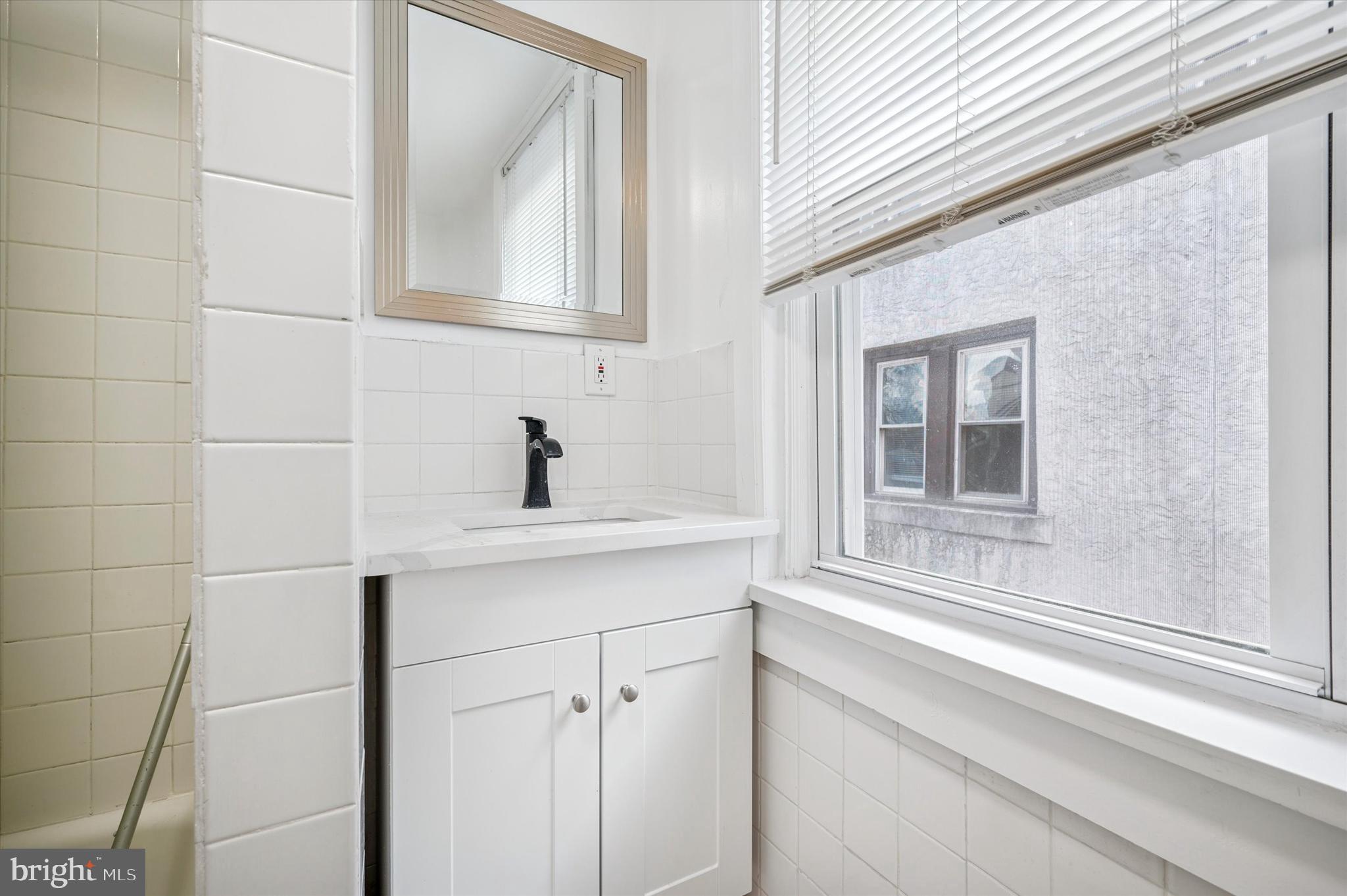 4518 Walnut Street Philadelphia, PA 19139 - Photo 18 of 36 a bathroom with a sink a vanity and mirror