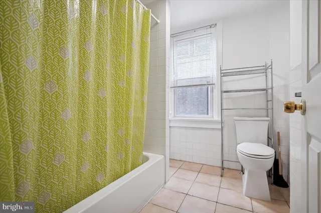 a bathroom with a toilet and a shower curtain
