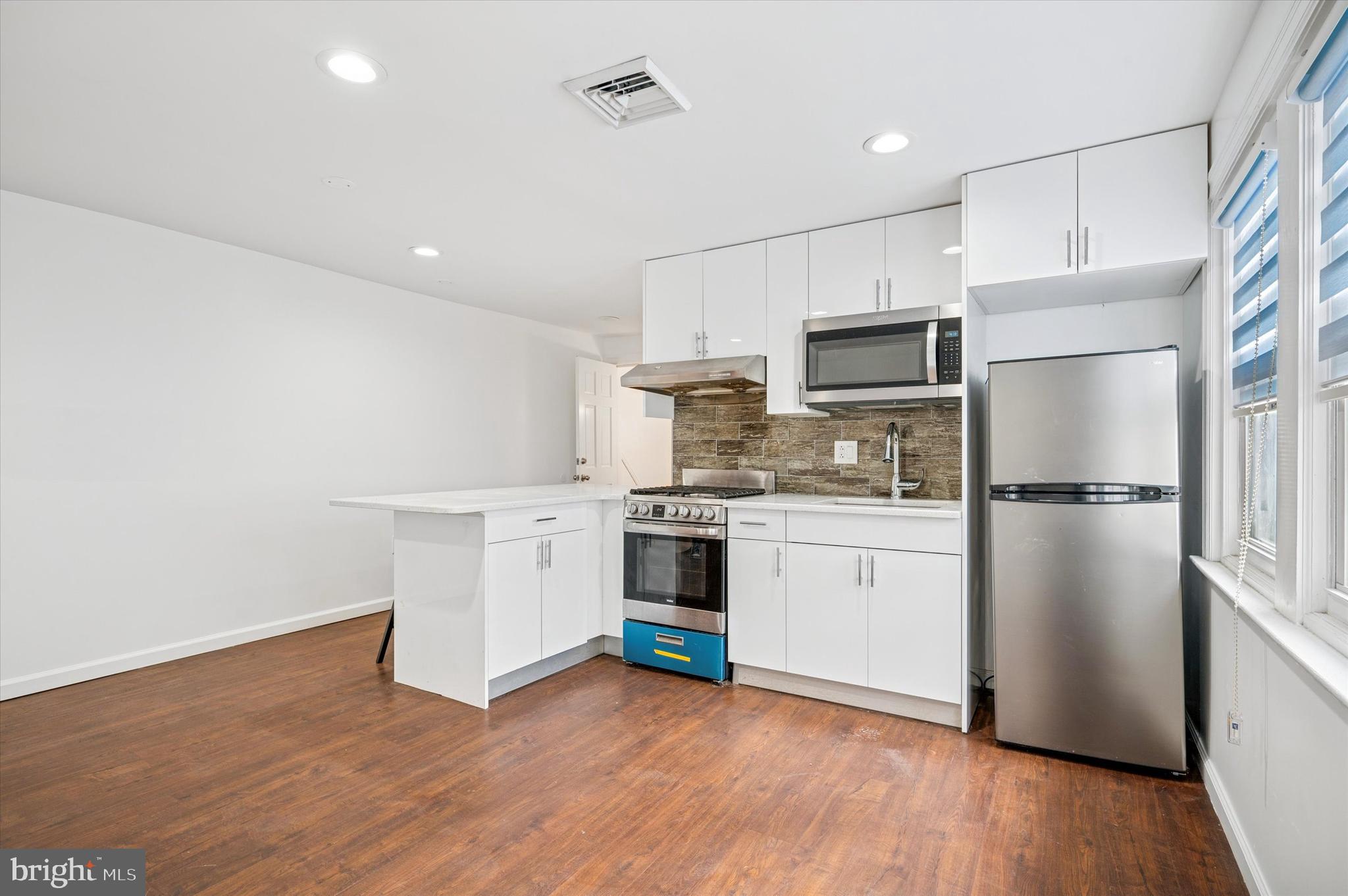 4518 Walnut Street Philadelphia, PA 19139 - Photo 26 of 36 a kitchen with a refrigerator and white cabinets