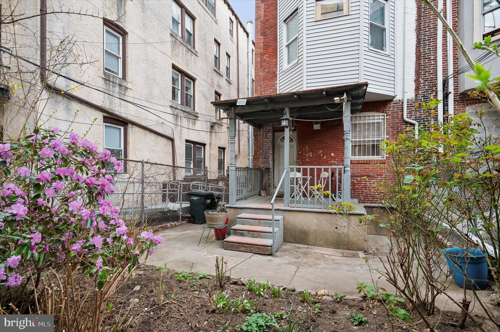 4518 Walnut Street Philadelphia, PA 19139 - Photo 34 of 36 a view of a house with a small yard and flower plants