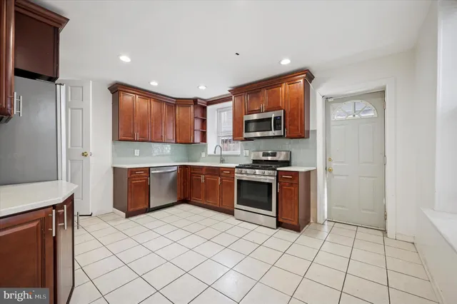 a kitchen with stainless steel appliances a refrigerator sink and microwave