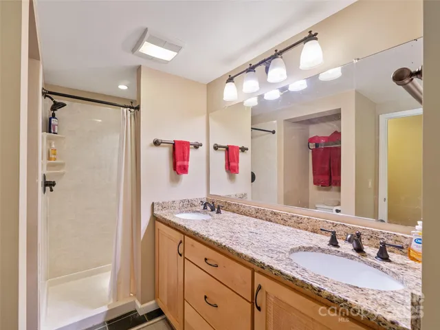 a bathroom with a granite countertop sink mirror and shower