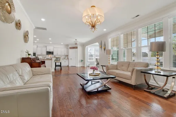 a kitchen with granite countertop white cabinets appliances and a wooden floor