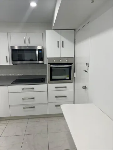 a kitchen with a cabinets appliances and a counter top
