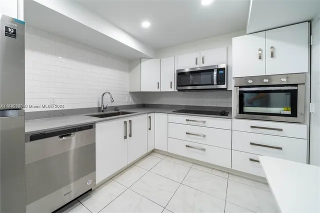 a kitchen with cabinets stainless steel appliances and sink