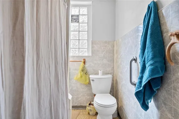 a white toilet sitting next to a shower curtain