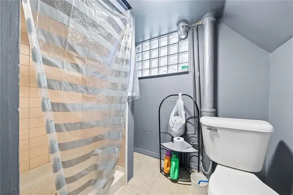 a white toilet sitting next to a shower curtain
