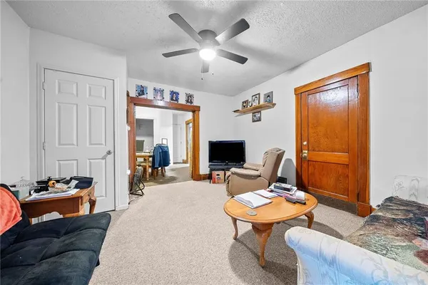 a living room with furniture kitchen view and a window