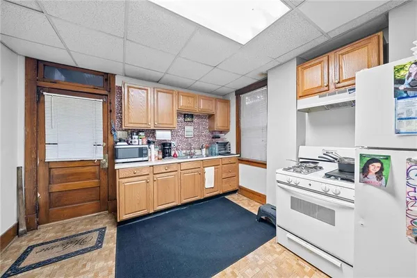 a kitchen with stainless steel appliances a stove a sink and white cabinets