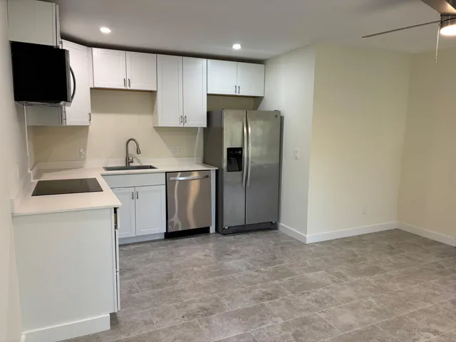 a kitchen with stainless steel appliances granite countertop a refrigerator sink and microwave