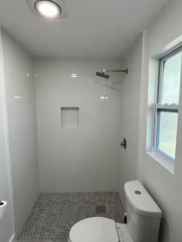 a bathroom with a toilet sink and window