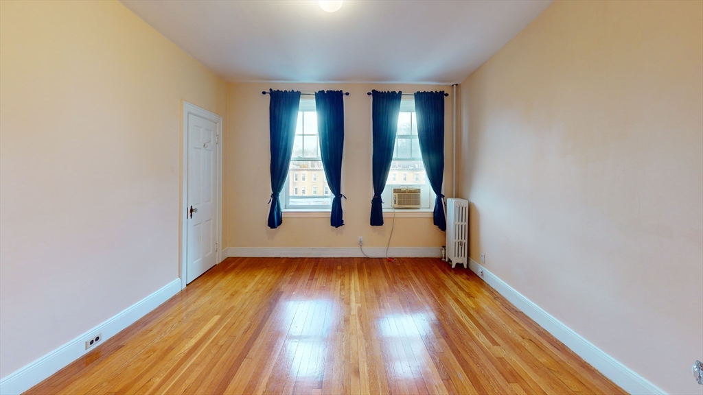 10 Jamaicaway, Unit 24 Boston, MA 02130 - Photo 4 of 9 wooden floor in an empty room with a window