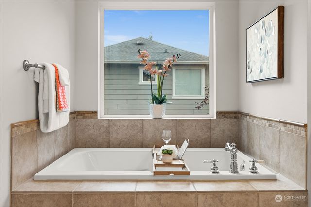 a bathroom with a tub sink and mirror