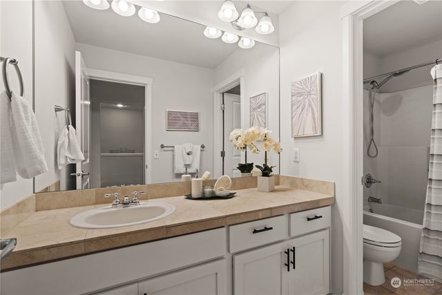 a bathroom with a sink a toilet and a mirror