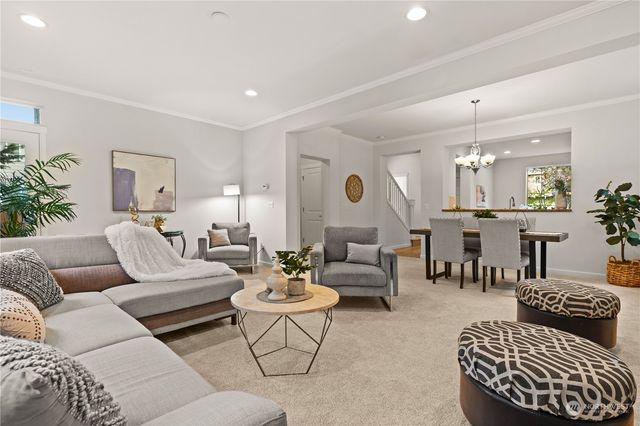 a living room with furniture potted plant and kitchen view
