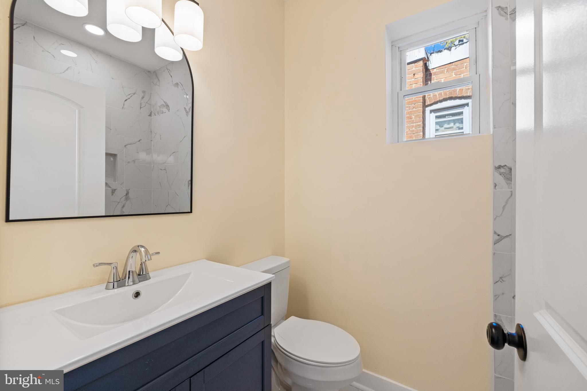 6 South Payson Street Baltimore, MD 21223 - Photo 11 of 17 a bathroom with a sink a toilet and mirror